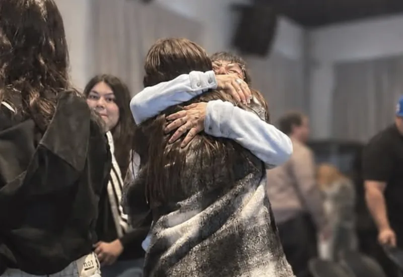 Duas pessoas abraçadas durante um encontro do Amar Más.