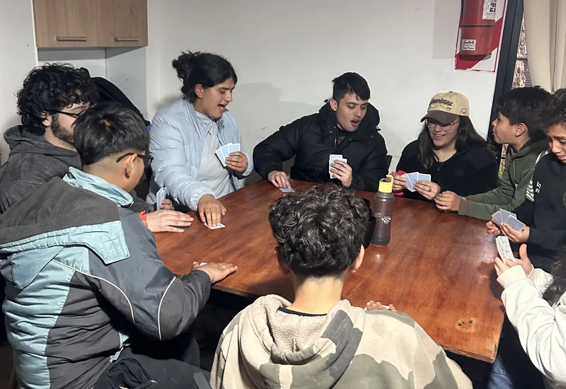 Jovens sentados ao redor de uma mesa, compartilhando uma tarde no Lar Sierra Dorada.